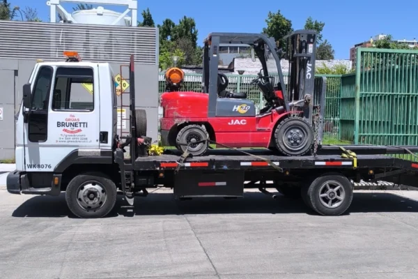 Camión Grúas Brunetti transportando grúa horquilla para empresa en Región Metropolitana
